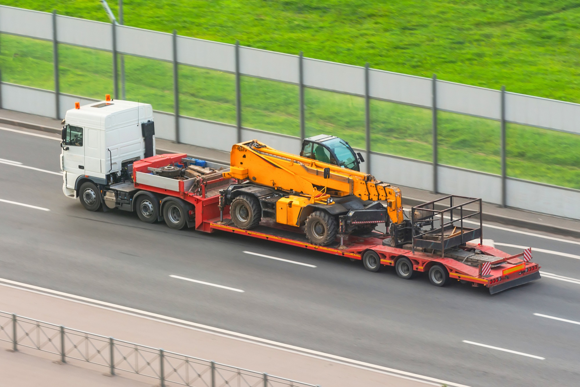 A truck with a trailer platform transporting equipment